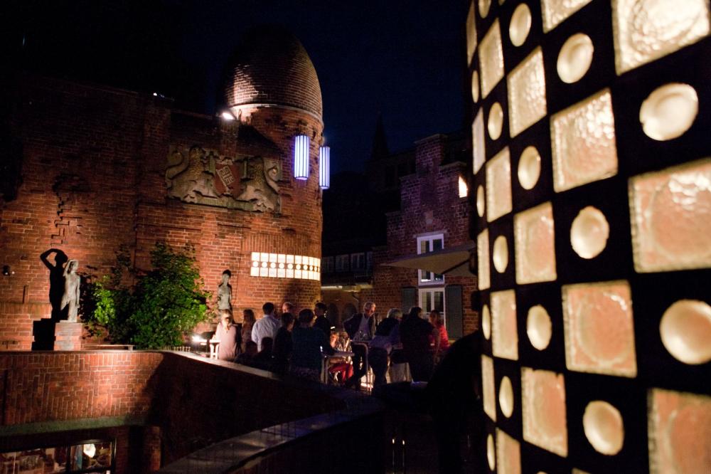 Terrasse mit Besuchern bei Nacht